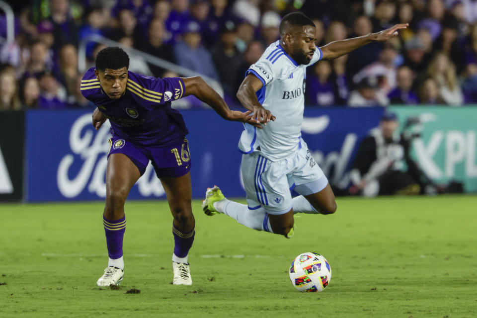 Orlando City midfielder Wilder Cartagena, left, and CF Montréal defender Aaron Herrera go after the ball during the first half of an MLS soccer match Saturday, Feb. 24, 2024, in Orlando, Fla. (AP Photo/Kevin Kolczynski)