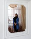 Shamsia Alizada,18, who has come top in the country's university entrance exam, is reflected in a mirror after an interview at her house in Kabul