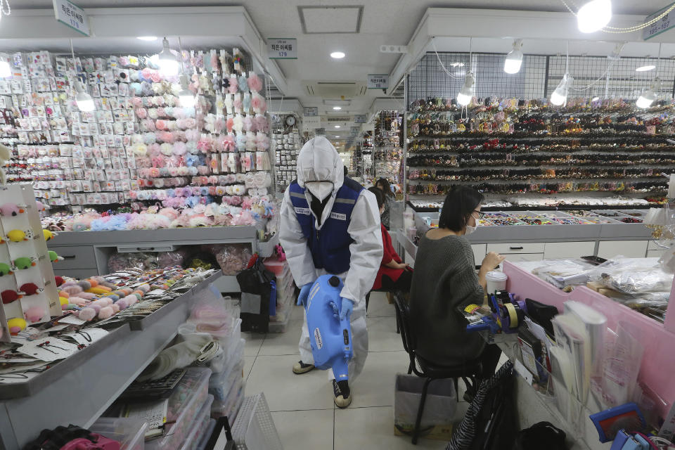 A worker wearing protective gears sprays disinfectant inside a store as a precaution against a new coronavirus at Namdaemun Market in Seoul, South Korea, Wednesday, Feb. 5, 2020. Deaths from a new virus rose to 490 in mainland China on Wednesday while new cases on a Japanese cruise ship, in Hong Kong and in other places showed the increasing spread of the outbreak and renewed attention toward containing it. (AP Photo/Ahn Young-joon)