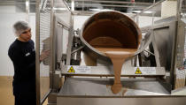 A worker pours chocolate onto a machine at Nestle's Product Technology Centre in York, Britain, March 21, 2018. REUTERS/Phil Noble