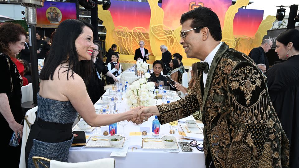 Lucy Liu, wearing a gown by Bibhu Mohapatra, and Karan Johar exchange a greeting at the Gold Gold 2024. - Michael Kovac/Getty Images