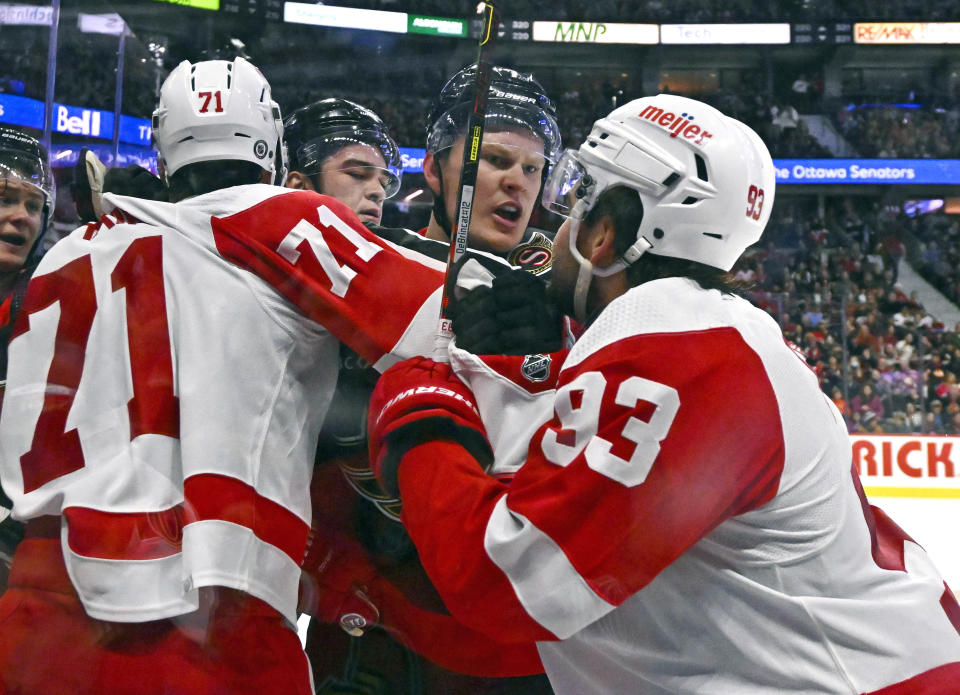 Detroit Red Wings centre Dylan Larkin (71) tries to keep Ottawa Senators left wing Brady Tkachuk (7) from Red Wings right wing Alex DeBrincat (93) as they argue during the first period of an NHL hockey action in Ottawa, Ontario, Saturday, Oct. 21, 2023. (Justin Tang/The Canadian Press via AP)