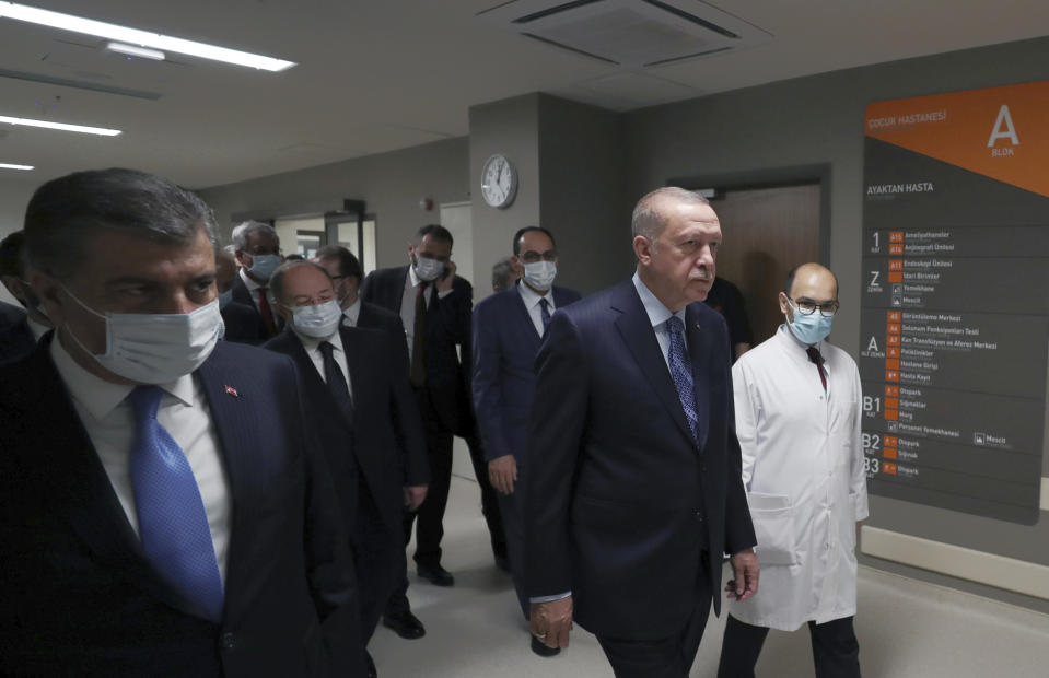 In this photo provided by the Turkish Presidency, Turkey's President Recep Tayyip Erdogan, front center, arrives to attend the inauguration ceremony for Basaksehir Pine and Sakura City Hospital, in Istanbul, Thursday, May 21, 2020. Japanese Prime Minister Shinzo Abe who participated by videoconference the ceremony has called for international cooperation against the new coronavirus, saying any drug or vaccine developed against the virus must be made "fairly" accessible. (Turkish Presidency via AP)