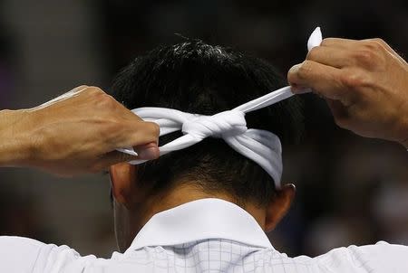 Japan's Kei Nishikori ties his head band during his fourth round match against France's Jo-Wilfried Tsonga at the Australian Open tennis tournament at Melbourne Park, Australia, January 24, 2016. REUTERS/Tyrone Siu TPX IMAGES OF THE DAY