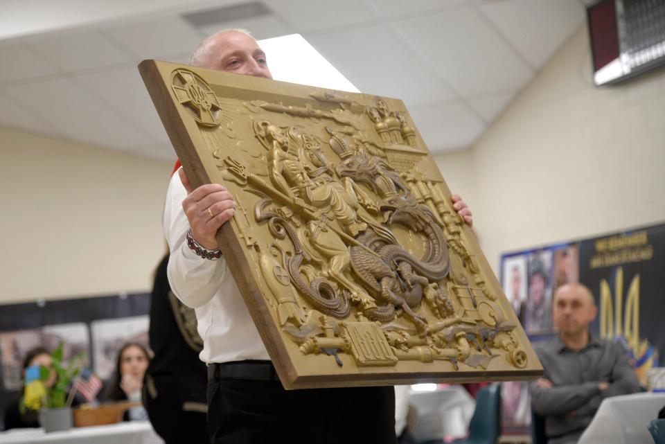 Roman Marchuk auctions one of his wood cutting during a charity fundraiser on Sunday, February 25, 2024 at St. Stephen Ukrainian Catholic Church in Toms River, New Jersey. An anonymous person sent $1,500 via a cash app and requested that the artwork be used at a future auction.