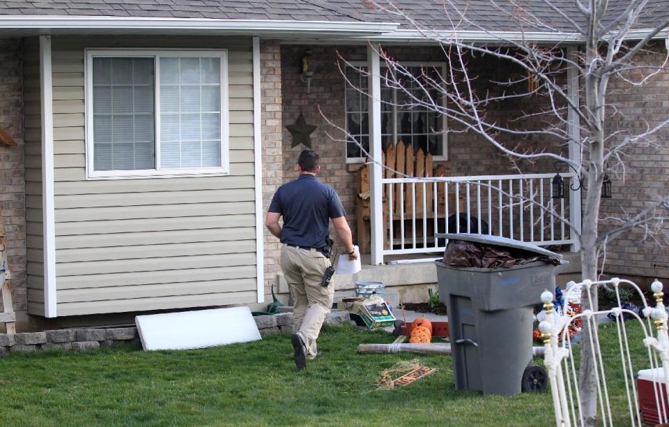 Pleasant Grove Police investigate the scene where seven infant bodies were discovered and packaged in separate containers at a home in Pleasant Grove, Utah, Sunday, April 13, 2014. According to the Pleasant Grove Police Department, seven dead infants were found in the former home of Megan Huntsman, 39. Huntsman was booked into jail on six counts of murder. (AP Photo/Rick Bowmer)