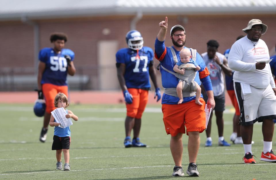 Savannah State co-offensive coordinator Nate Baker coaches with his little assistants in tow during a Tigers practice in 2021.