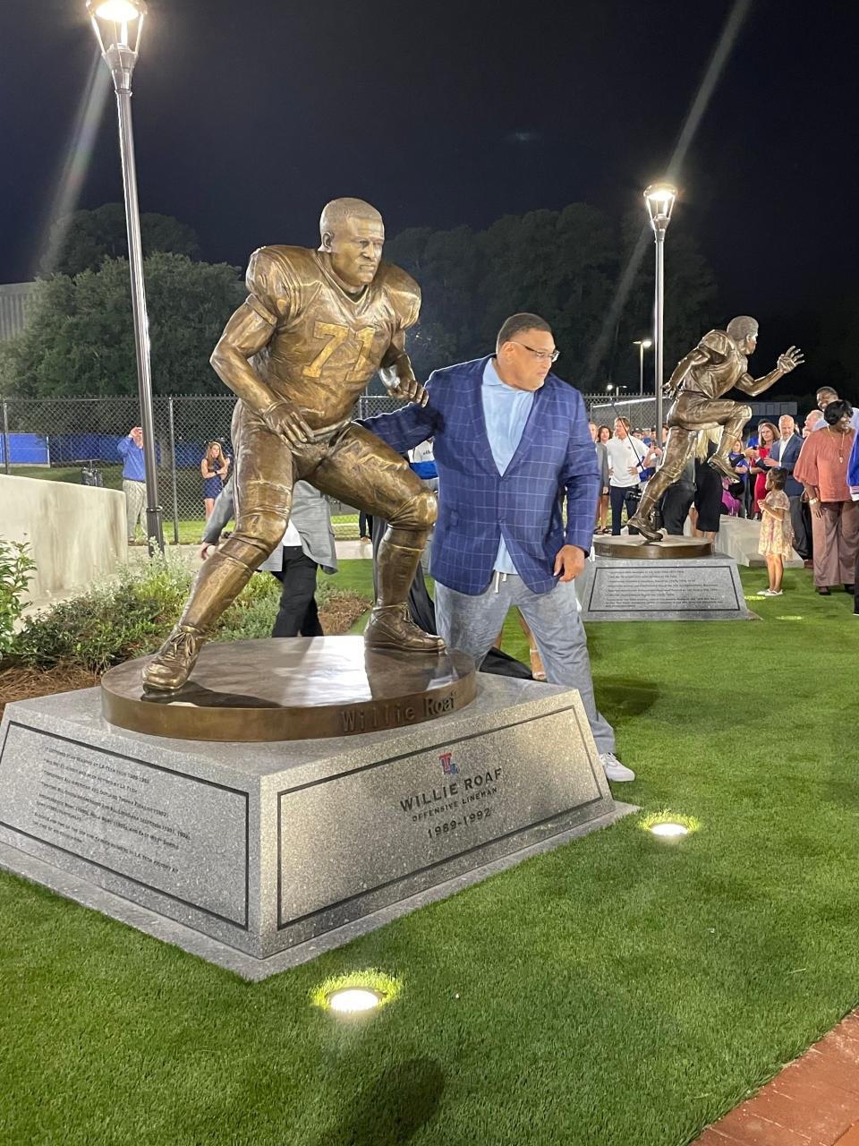 Louisiana Tech Hall of Famer Willie Roaf stands next to his new statute at Joe Aillet Stadium.