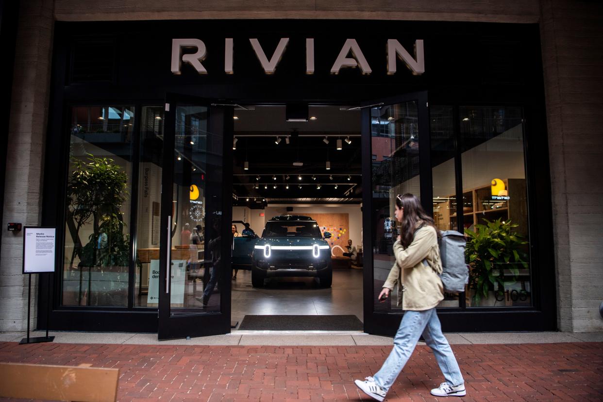 A pedestrian passes the new Rivian showroom at 5th and Broadway shopping center in Nashville, Tenn., Wednesday, Oct. 11, 2023.