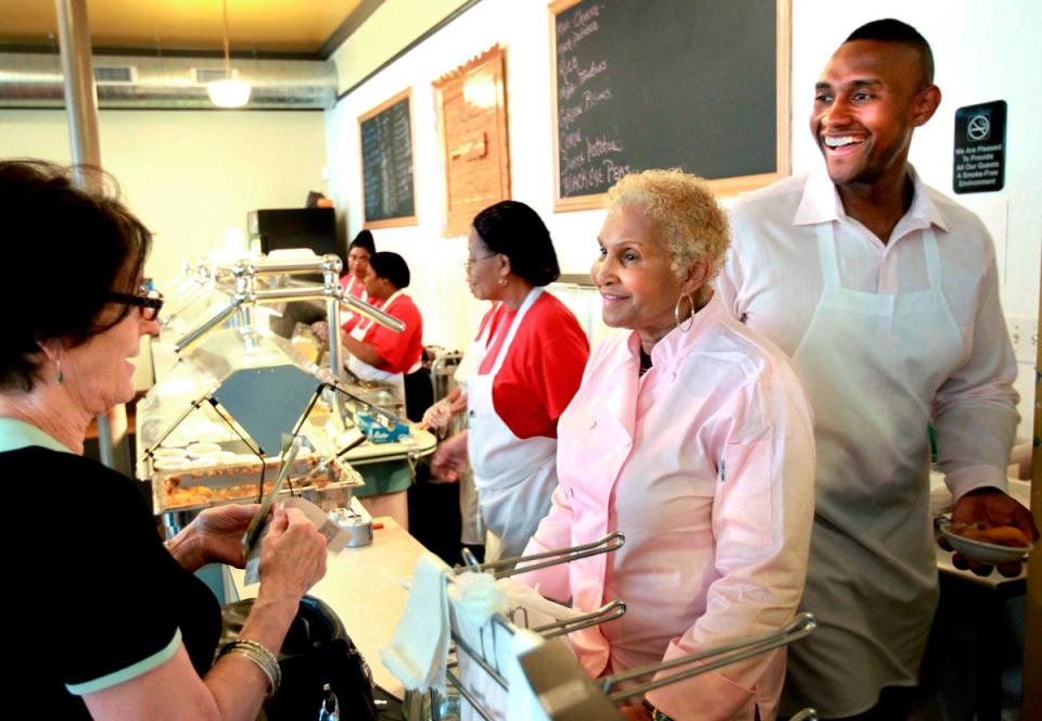 SFILE - A customer picks up some food to-go from Sweetie Pie’s owner Robbie Montgomery, center, and Montgomery’s son, Tim Norman