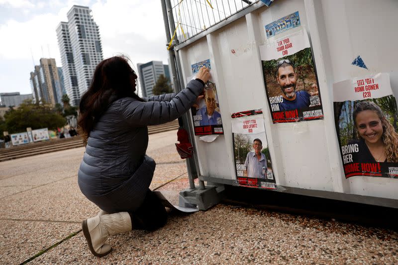 Dahlia Cooper hangs a photo of her father-in-law, kidnapped by Palestinian Islamist group Hamas, in Tel Aviv