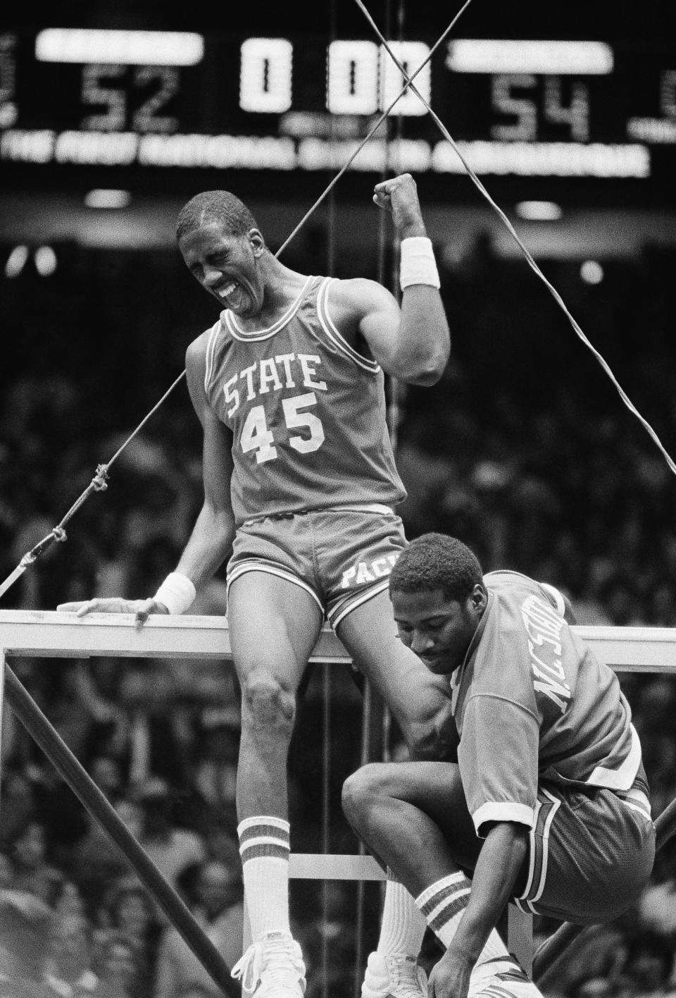 FILE - In this early Tuesday, April 5, 1983, file photo, North Carolina center Cozell McQueen (45) yells while standing on the rim after defeating Houston 54-52 to win the NCAA college basketball championship in Albuquerque, N.M. Joining McQueen on the rim is teammate Ernie Myers. There are still moments, even after nearly four decades, when Ernie Myers has trouble believing it all really happened for his North Carolina State team. (AP Photo/File)