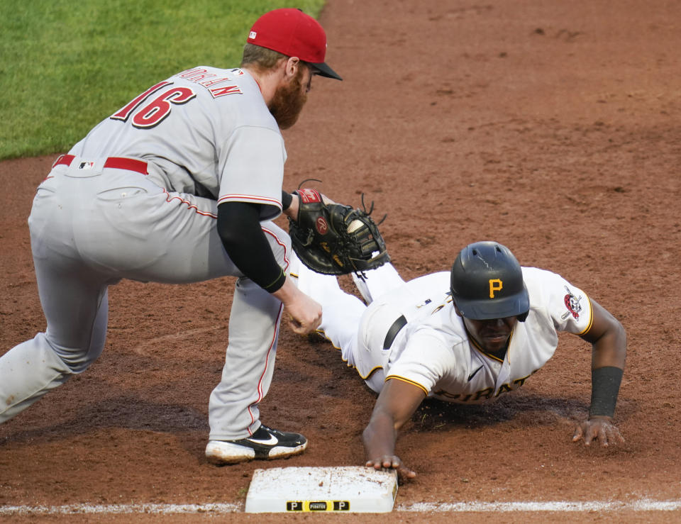 Pittsburgh Pirates' Ke'Bryan Hayes, right, beats the tag by Cincinnati Reds first baseman Colin Moran on a pickoff attempt during the third inning of a baseball game Thursday, May 12, 2022, in Pittsburgh. (AP Photo/Keith Srakocic)