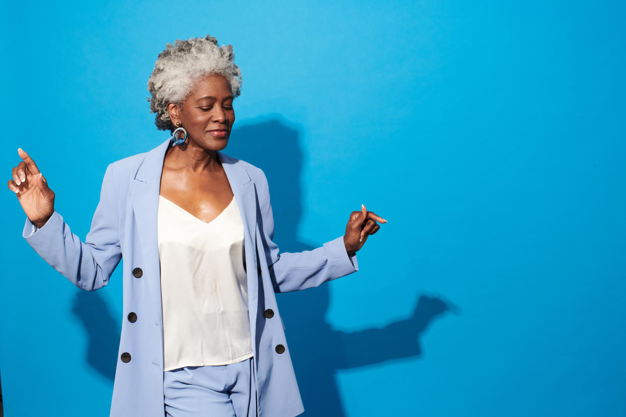 Close-up portrait of a beautiful senior woman against blue background