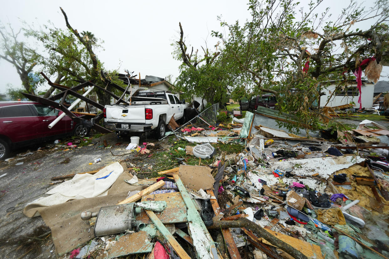 The frame, top left, of a mobile home rests atop a home and a vehicles after a tornado hit Saturday, May 13, 2023, in the unincorporated community of Laguna Heights, Texas near South Padre Island. Authorities say one person was killed when a tornado struck the southernmost tip of Texas on the Gulf coast. (AP Photo/Julio Cortez)