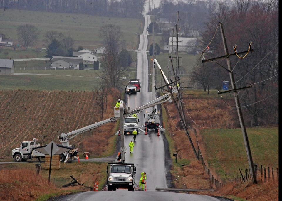 Utility crews work to reset utility poles on Moreland Road near Apple Creek Monday as some AEP customers in Wayne and Holmes counties remain without electricity following Saturday's damaging winds.