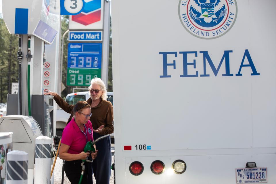 Less Feldser, whose house was destroyed by a fire speaks to a FEMA employee at a gas station after he was denied access to his neighborhood to survey his home on June 24, 2024 in the Village of Ruidoso.