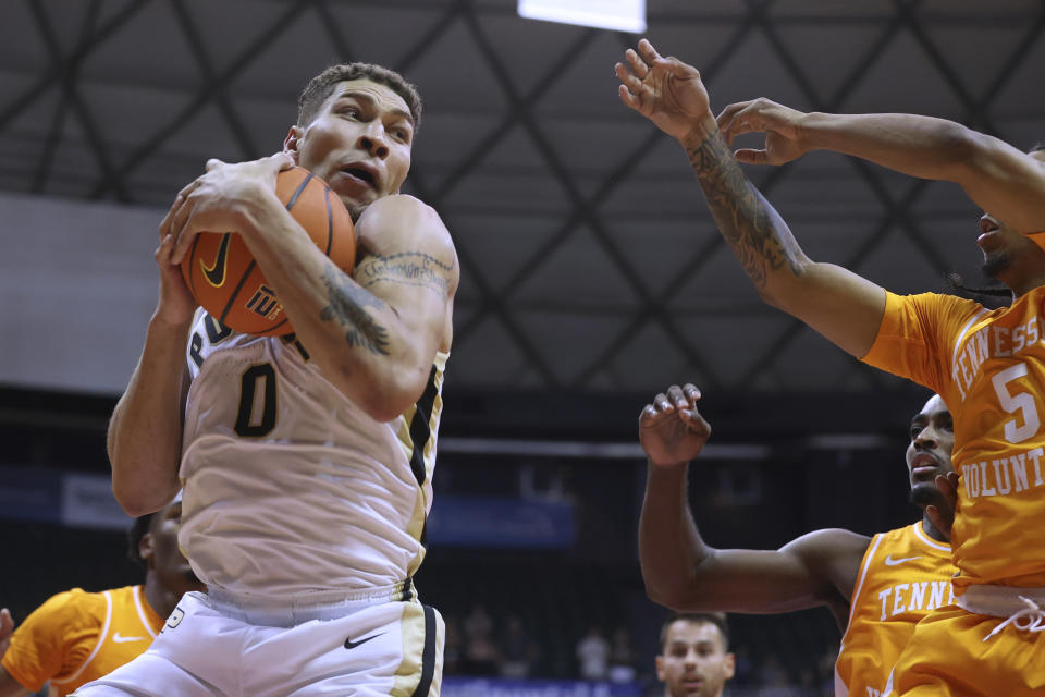 Purdue forward Mason Gillis (0) grabs a rebound from Tennessee players, including Zakai Zeigler (5), during the first half of an NCAA college basketball game Tuesday, Nov. 21, 2023, in Honolulu. (AP Photo/Marco Garcia)