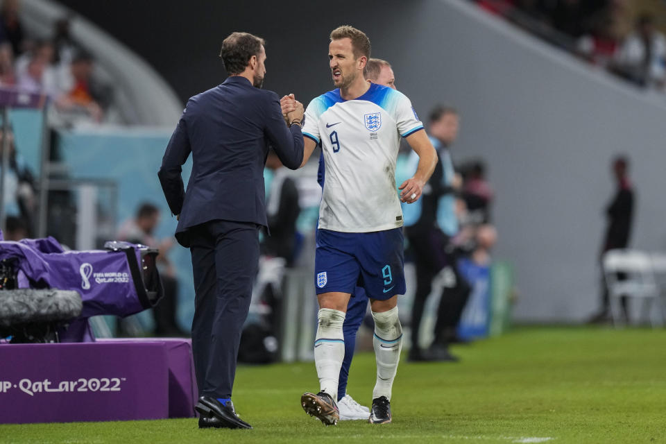 England's Harry Kane, right, greets England's head coach Gareth Southgate during the World Cup group B soccer match between England and Wales, at the Ahmad Bin Ali Stadium in Al Rayyan , Qatar, Tuesday, Nov. 29, 2022. England won 3-0. (AP Photo/Frank Augstein)