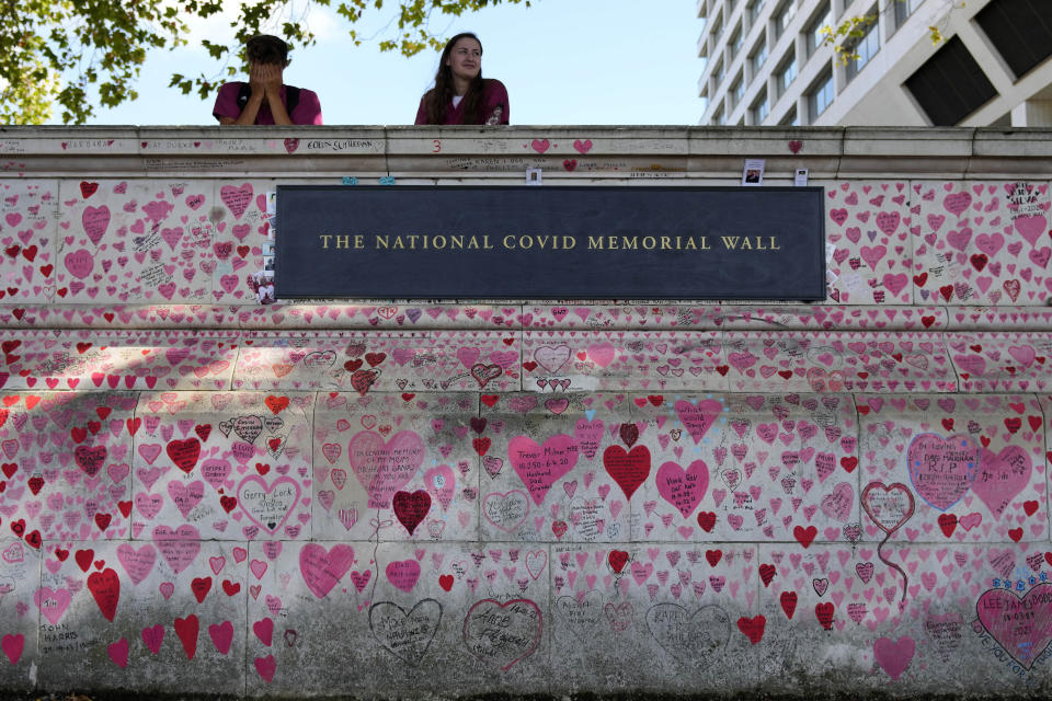 Nurses from the nearby hospital rest atop the National Covid Memory Wall in London, Thursday, Sept. 16, 2021. Although the number of people now contracting COVID-19 is way higher than this time last year — over 30,000 new infections a day — the British government has opted not to re-introduce further virus restrictions for England, as the vaccine drive this year has reduced the number of people requiring treatment for COVID-19 and subsequently dying. (AP Photo/Frank Augstein)