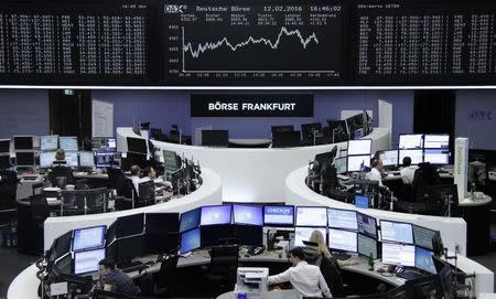 Traders work at their desks in front of the German share price index, DAX board, at the stock exchange in Frankfurt, Germany, February 12, 2016. REUTERS/Staff/Remote