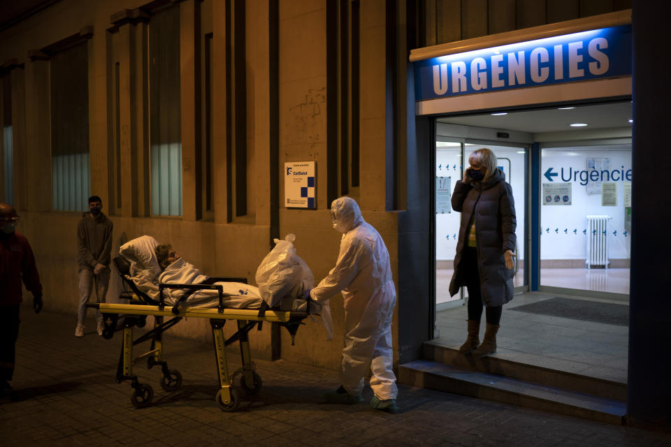 An elderly COVID-19 patient is transferred to an ambulance from a Hospital in Barcelona, Spain, Friday, March 27, 2020. The new coronavirus causes mild or moderate symptoms for most people, but for some, especially older adults and people with existing health problems, it can cause more severe illness or death. (AP Photo/Felipe Dana)