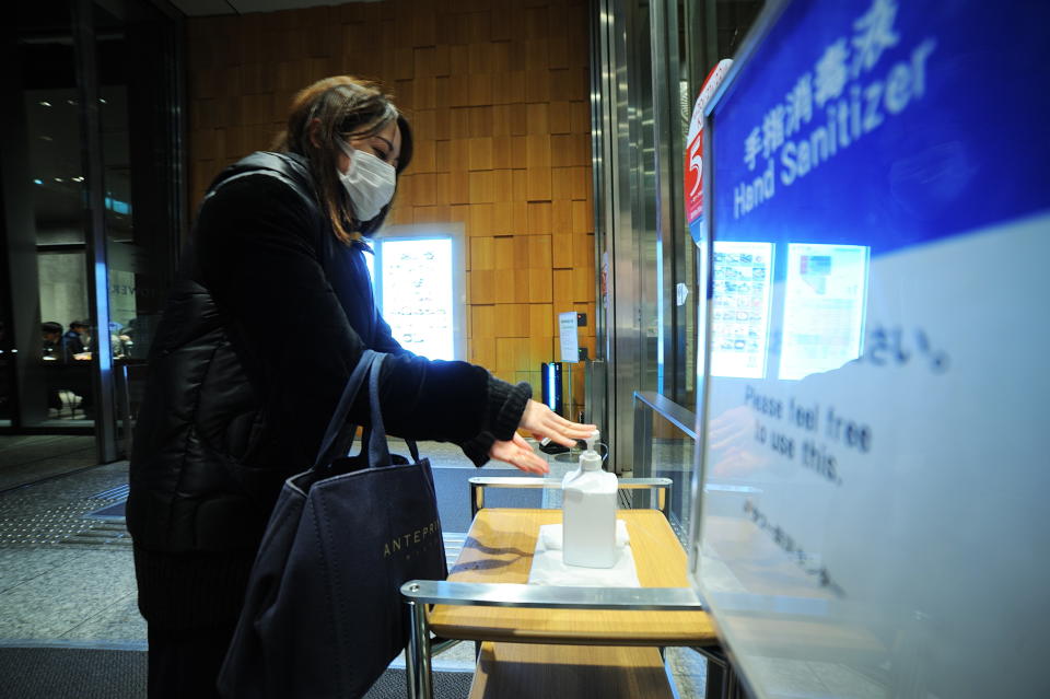 TOKYO, JAPAN - FEBRUARY 11 : A woman wearing mask uses a hand disinfectant as measures at a shopping mall on February 11, 2020, in Tokyo, Japan. Japan still continues to report several case of people infected by the coronavirus Covid-19 since the start of outbreak as well as on board the Diamond Princess cruise ship quarantined in Yokohama Bay for around 15 days. In Tokyo, Japanese citizens, foreign communities and tourists take measure to protect themselves against the Wuhan coronavirus Covid-19 by wearing mask and washing their hands with Hand Disinfectants installed in different places such at the entrance of several department stores, buildings, train stations and subways, in many firm, also in several public restrooms in the capital of Japan. (Photo by David Mareuil/Anadolu Agency via Getty Images)