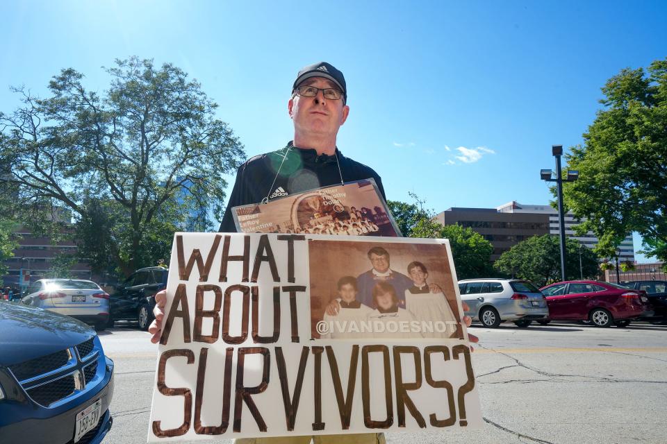 Chris O'Leary drove from St. Louis, Mo., to hold this sign outside the public funeral for former Archbishop Rembert Weakland Tuesday at the Cathedral of St. John the Evangelist.