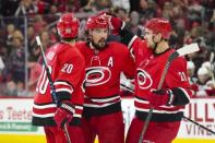 FILE PHOTO: Apr 4, 2019; Raleigh, NC, USA; Carolina Hurricanes defenseman Justin Faulk (27) is congratulated by center Sebastian Aho (20) and right wing Nino Niederreiter (21) after his second period goal against the New Jersey Devils at PNC Arena. Mandatory Credit: James Guillory-USA TODAY Sports