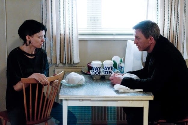 A man and a woman talk at a kitchen table in "The Girl With the Dragon Tattoo"