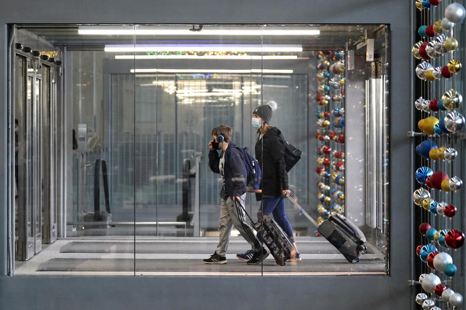 FILE - In this Sunday, Nov. 29, 2020 file photo, travelers walk through Terminal 3 at O'Hare International Airport in Chicago. The Transportation Security Administration said nearly 1.2 million people went through U.S. airports on Sunday, the highest number since the coronavirus pandemic gripped the country back in March, despite the pleadings of public health experts for people to stay home over Thanksgiving. (AP Photo/Nam Y. Huh, File)