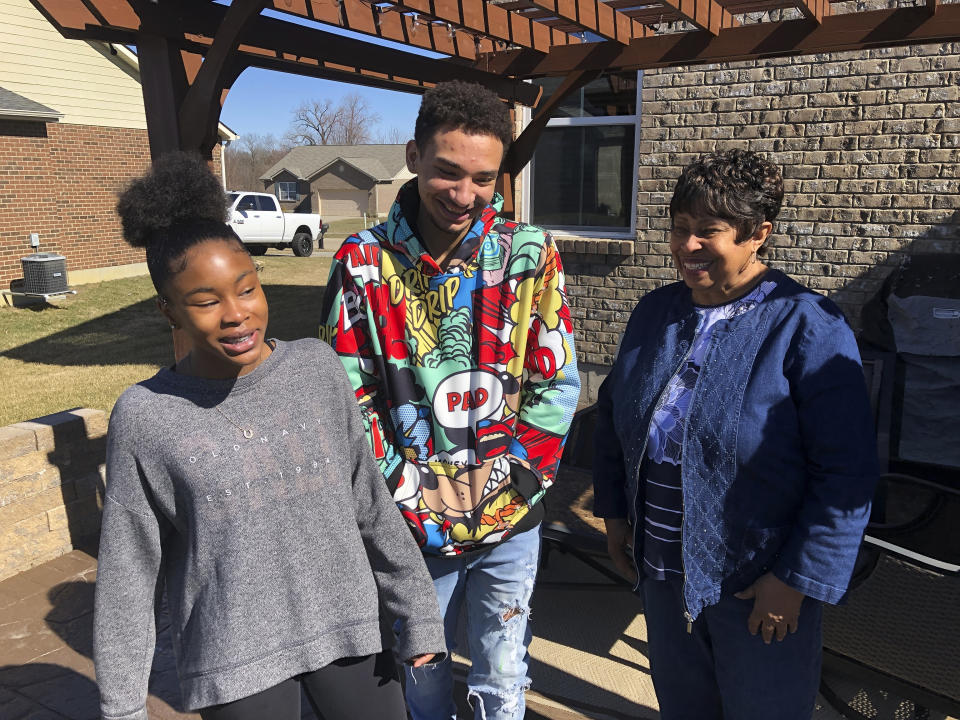 Brilee Carter, left,13, and Cobe Calhoun, 17, share a laugh with their great-grandmother, Doris Rolark, outside Rolark's daughter's home on March 7, 2021, in Monroe, Ohio. The pandemic and its isolating restrictions have been especially tough for many of the nation's some 70 million grandparents, many at ages when they are considered most vulnerable to the deadly COVID-19 virus. Rolark, of Middletown, Ohio, has always been active with the offspring. She raised three children mostly on her own, had five grandchildren (two now deceased), and has helped a lot with some of her 16 great-grandchildren. (AP Photo/Dan Sewell)