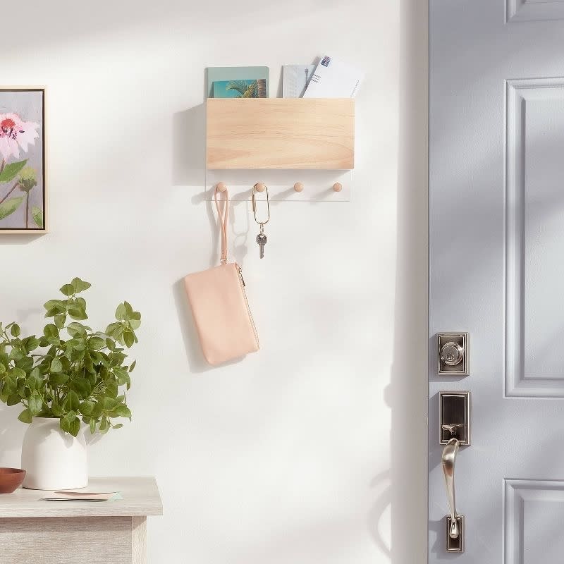 The mail and key holder mounted on a white wall