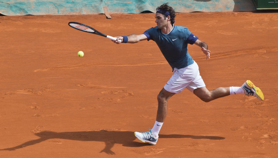 Roger Federer of Switzerland, returns the ball to Lukas Rosol of the Czech Republic during their third round match of the Monte Carlo Tennis Masters tournament in Monaco, Thursday, April 17, 2014. Federer won 6-4 6-1. (AP Photo/Michel Euler)