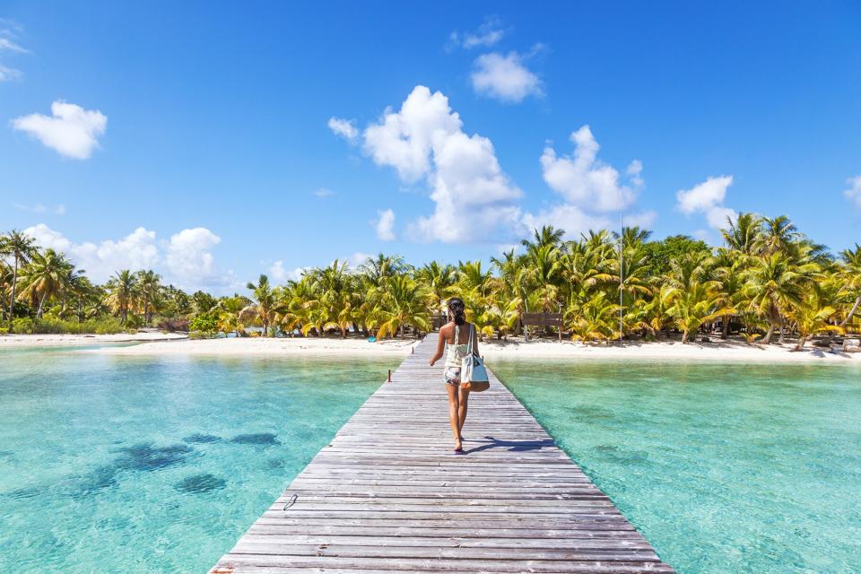 Tourist walking on jetty, Tikehau atoll, Tuamotu Archipelago, French Polynesia, Oceania