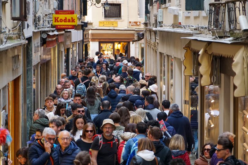 Tourists pass stores on the Merceria shopping street in Venice, Italy, on Saturday, April 8, 2023. Italy's upcoming budget outlook will probably incorporate a higher growth forecast for 2023 followed by a worsened outlook for subsequent years, according to people familiar with the matter. Photographer: Andrea Merola/Bloomberg via Getty Images