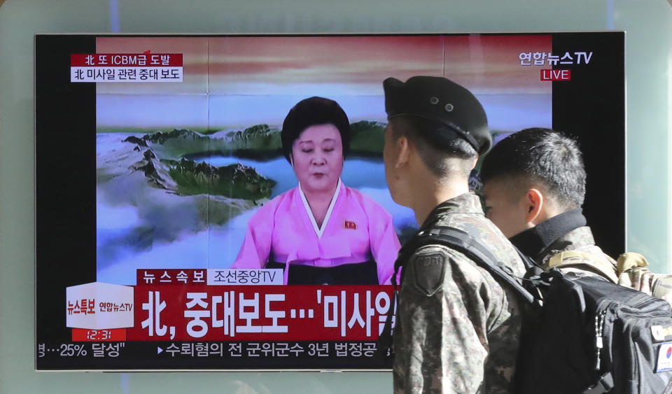 <em>South Korean soldiers walk by a TV screen showing the live broadcast about North Korea’s missile launch (AP)</em>