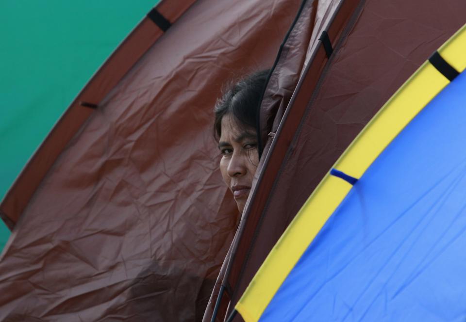 An anti-government protester looks out from her tent as she takes part in a rally at the Victory Monument in Bangkok January 21, 2014. Some Thai rice farmers have threatened to switch sides and join protesters trying to topple the government if they do not get paid for their crop, a worrying development for Prime Minister Yingluck Shinawatra whose support is based on the rural vote. REUTERS/Chaiwat Subprasom (THAILAND - Tags: POLITICS CIVIL UNREST TPX IMAGES OF THE DAY)