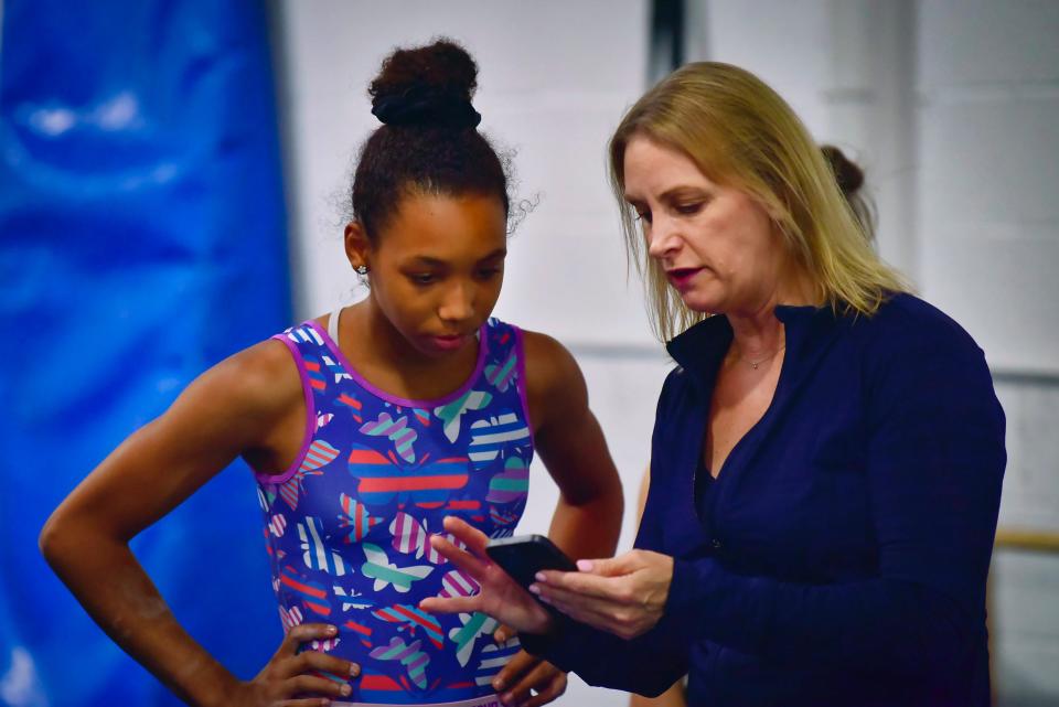 Olivia Kelly, a Mahwah resident who is an Olympic hopeful for Team Barbados, listens to Faith Baranowski, National Team Coach, during her practice at North Stars Gymnastics Academy in Boonton Tuesday on 07/25/22.