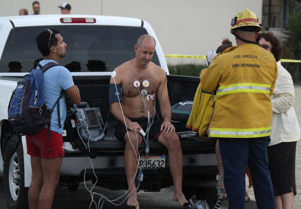 A man is treated by a paramedics after a lightning strike in the water in Venice, California July 27, 2014. (REUTERS/Jonathan Alcorn)