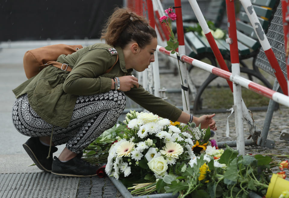 A young woman lays a candle among flowers left by mourners outside the French Embassy the day after the terror attack in Nice.  (Photo by Sean Gallup/Getty Images) 