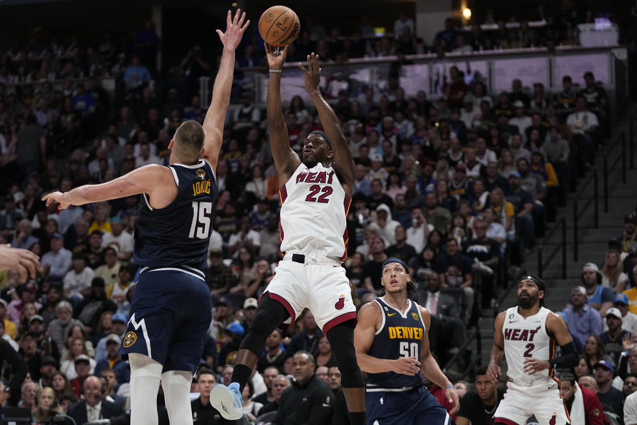 Miami Heat forward Jimmy Butler (22) shoots over Denver Nuggets center Nikola Jokic (15) during the first half of Game 2 of basketball's NBA Finals, Sunday, June 4, 2023, in Denver. (AP Photo/Mark J. Terrill, Pool)