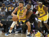 Sacramento Kings guard De'Aaron Fox guards Golden State Warriors guard Stephen Curry (30) during the second half of an NBA basketball game in Sacramento, Calif., Sunday, Oct. 24, 2021. The Warriors won 119-107. (AP Photo/Randall Benton)