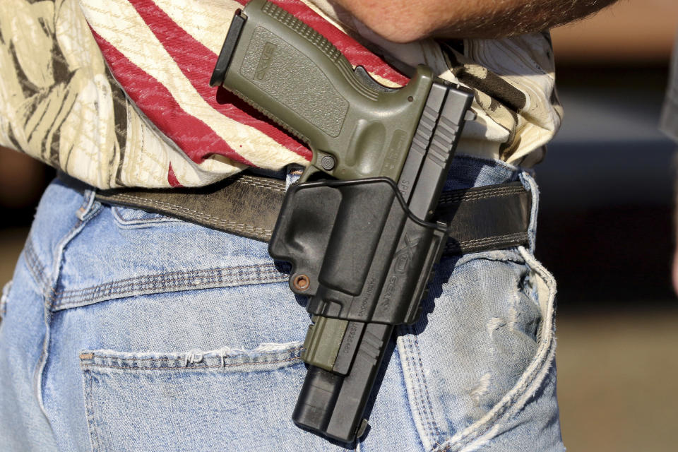 FILE - In this Oct. 9, 2015 file photo, Michael Johnson wears a firearm as he waits outside of Roseburg Municipal Airport for President Barack Obama's arrival in Roseburg, Ore. An Oregon judge will decide during a trial starting Monday, Sept. 18, 2023 whether a gun control law approved by voters last year is lawful under the state constitution. (AP Photo/Ryan Kang, File)