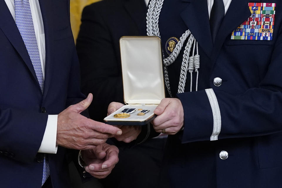 A military aide hands a Presidential Citizens Medal, the nation's second-highest civilian honor, to President Joe Biden as a citation is read for U.S. Capitol Police officer Caroline Edwards during a ceremony to mark the second anniversary of the Jan. 6 assault on the Capitol in the East Room of the White House in Washington, Friday, Jan. 6, 2023. (AP Photo/Patrick Semansky)