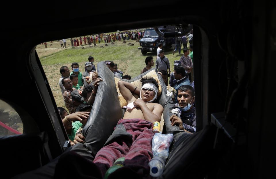 Nepalese soldiers carry a wounded man to a waiting Indian air force helicopter as they evacuate victims of Saturday's earthquake from Trishuli Bazar to Kathmandu airport in Nepal, Monday, April 27, 2015.  (AP Photo/Altaf Qadri)