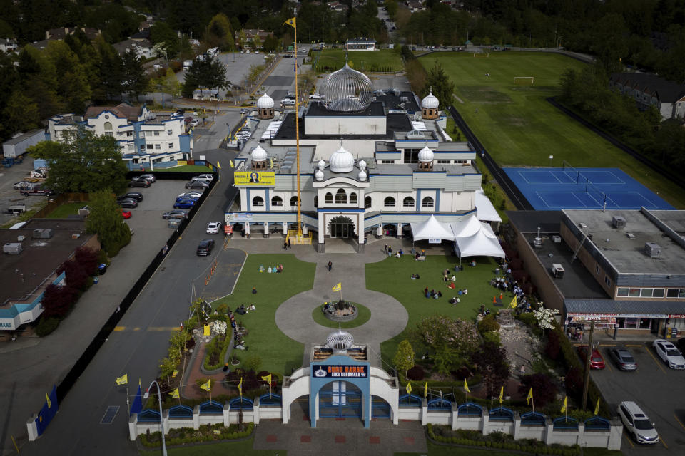 In this photograph taken with a drone, people sit on the front lawn of the Guru Nanak Sikh Gurdwara, in Surrey, B.C. on Friday, May 3, 2024. (Ethan Cairns/The Canadian Press via AP)