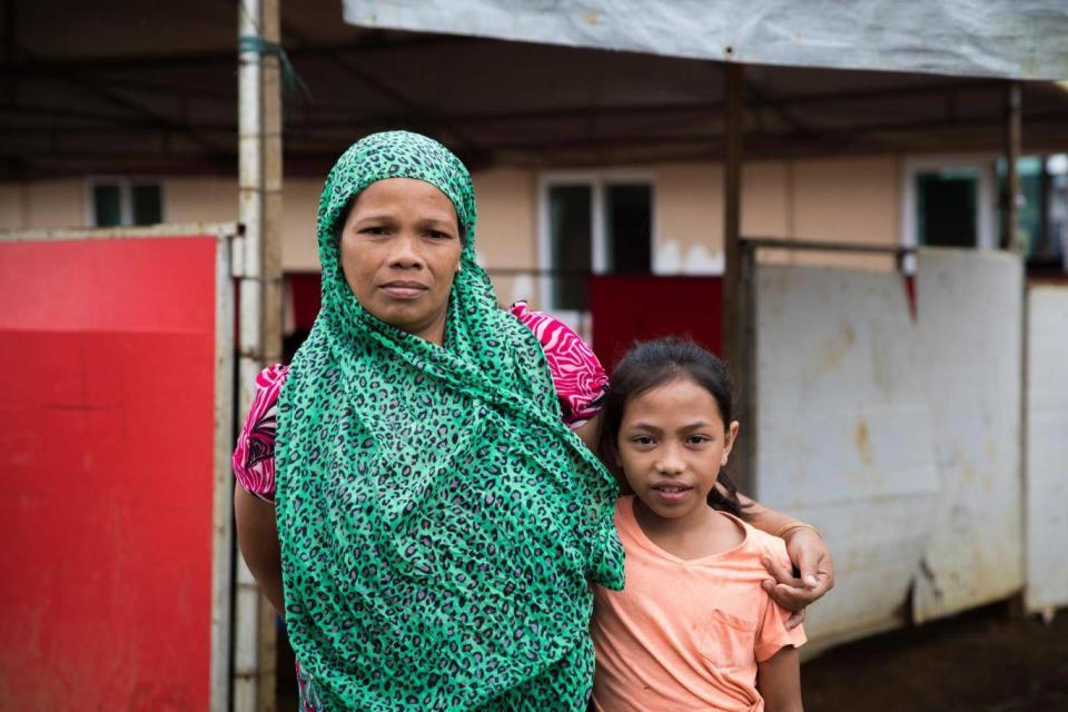 Vilma, 38, and her 10 year-old daughter Aisah stand outside a Save the Children temporary learning centre near Marawi (Hanna Adcock/Save the Children)