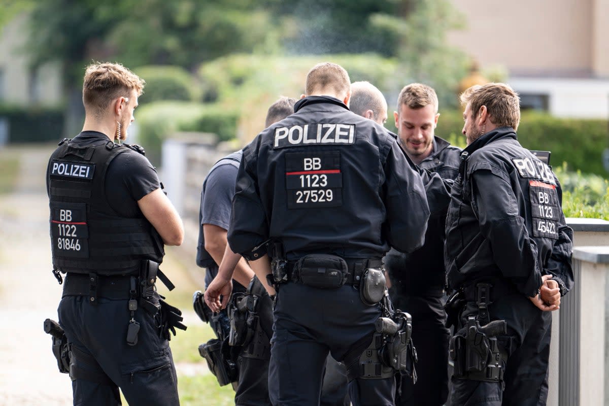 Police officers coordinate the search for a wild animal in a residential area in Teltow, Germany (AP)