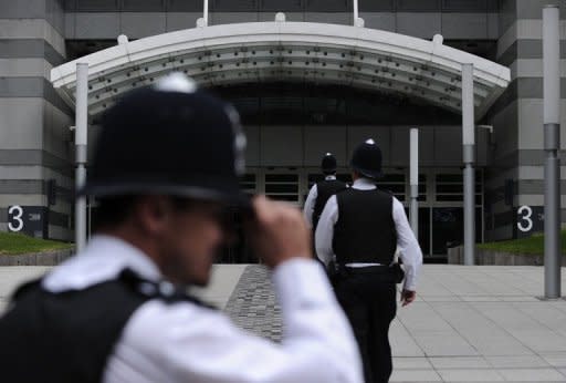 File photo of police outside the offices of News International in London. British police investigating phone hacking at Rupert Murdoch's News of the World arrested the former chief reporter of the tabloid for allegedly intimidating a witness